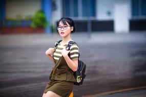 girl with a backpack on a city street in a blurred background