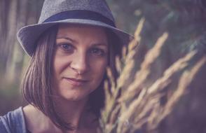 portrait of a woman in a hat on nature in a blurred background