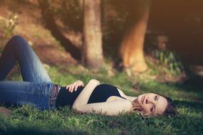 beautiful Woman lays on her back on Grass