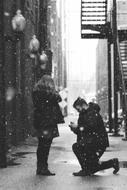 marriage proposal on a city street in black and white background