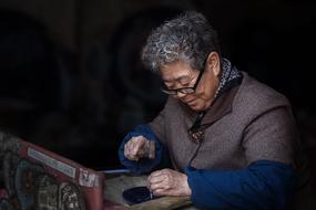 an elderly woman works with her hands