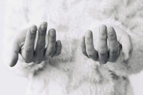 Black and white photo with close-up of the woman holding hands with fingers up