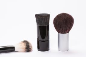 Different, colorful cosmetic brushes, on white surface