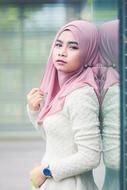asian girl in pink hijab by the glass wall