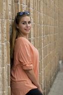 girl with sunglasses posing near the wall