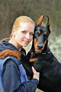 girl with a doberman on a blurred background