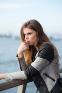 a girl stands near the railing in the port