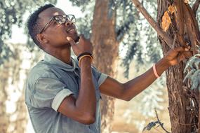 young man looking at a tree in africa