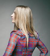 blonde in a plaid shirt on a gray background