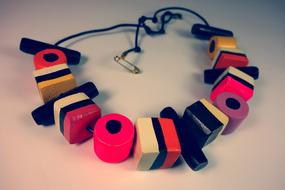 Close-up of the colorful and beautiful licorice candies on the necklace, on the white surface