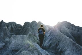 a woman with a backpack walks in the mountains