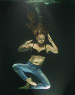 girl in jeans posing underwater