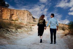 couple in love walking holding hands along the road