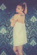 blonde with a tattoo in a white dress