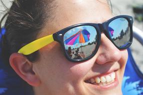the face of a smiling girl in sunglasses