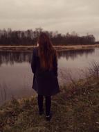 Girl on the shore of the river with plants