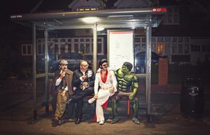 people in carnival costumes at bus station