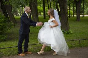 photo of the bride and groom walking in the park