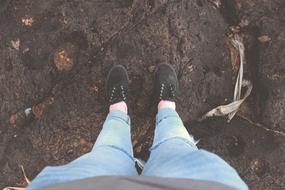 Top view of the legs of the child with black shoes