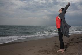 happy free woman on the beach on a cloudy day