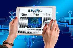 Bitcoin on screen of tablet in female hands at abstract Electronic background