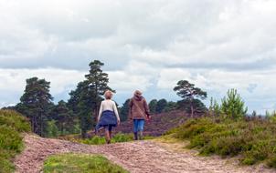 two woman Walking away on soil road in wilderness