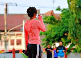 sportive woman Drinks water from bottle on street