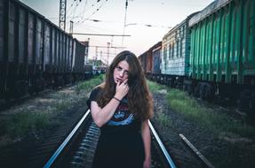 girl on the railroad between trains