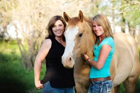 photo of two girlfriends and a horse on the farm