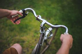 male hands holding handlebar of bicycle