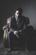 portrait of mature Man sits on armchair