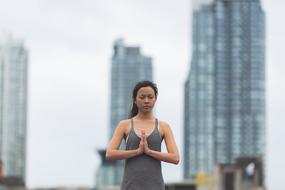 young woman doing yoga exercise in city