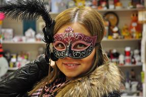 smiling blonde girl with carnival Mask on face in shop