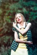 blonde in a plaid vest on a background of nature