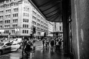 busy People on wet street in city, black and white