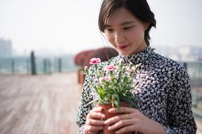 Girl is standing with the colorful flowers