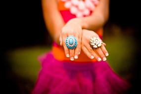 female hands with rings on blurred background