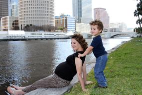 pregnant mom with her son on the city embankment