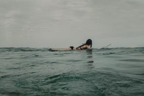 paddling woman in surfboard
