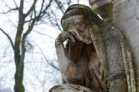 sculpture of a sad woman in a cemetery