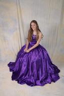 girl in a purple dress against a white wall