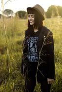Stylish woman on the landscape with the grass