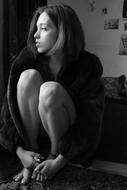 Black and white photo with the profile portrait of the sitting girl, in light