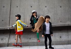 Kids in the colorful clothing, posing near the wall