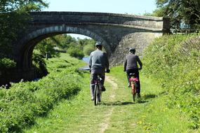 couple on bicycles riding a trail along the canal