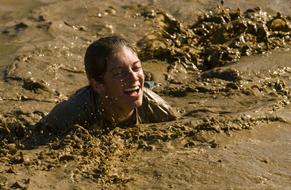 photo of a laughing girl in the mud