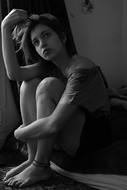 serious young girl sits looking up
