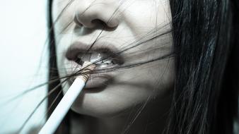 Black and white photo of a woman, with the cigarette in the teeth