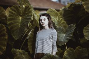 photo of a girl on a background of burdock leaves