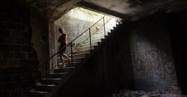 Person, going down on the beautiful stairs with graffities, in light, in France